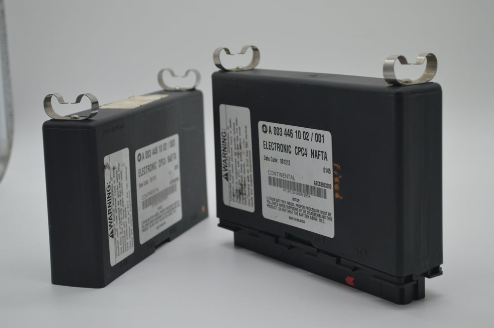 Two Freightliner CPC4 modules side-by-side on repair bench, both labeled A0034461002, highlighting electronic controller used in Detroit Diesel-equipped Cascadia trucks.