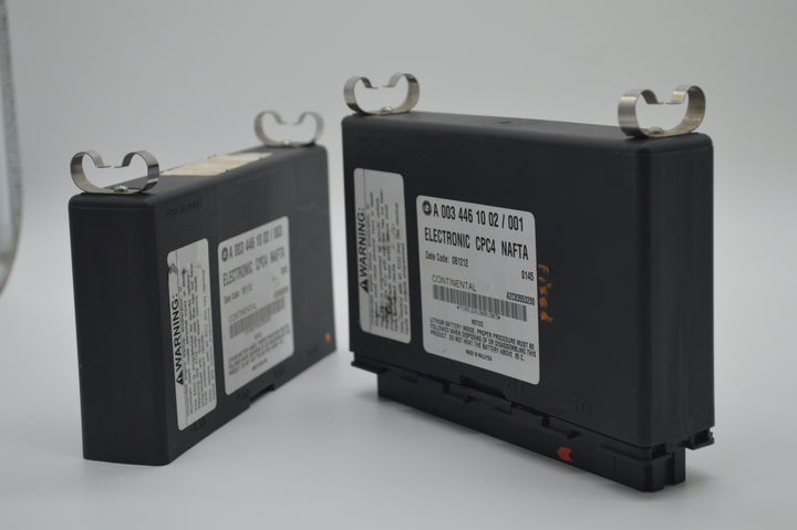 Dual CPC4 modules for Freightliner trucks positioned side by side, showing detailed Continental manufacturing labels and module casing.