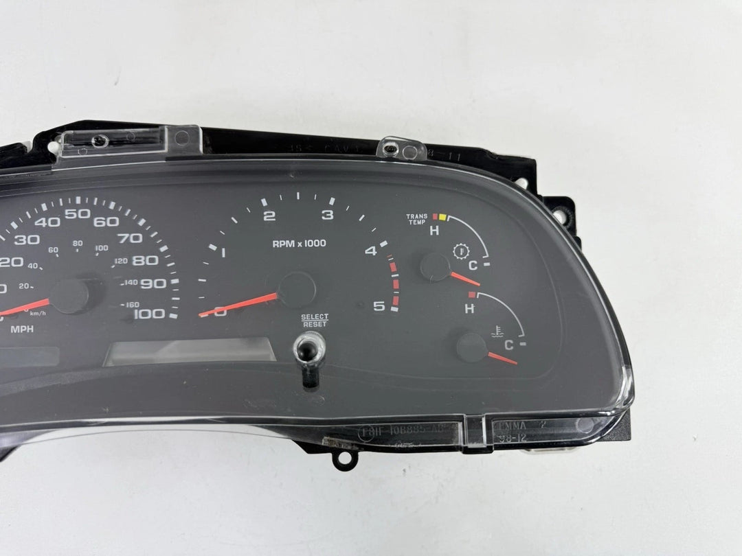 Close front view of a 2002–2004 Ford Super Duty instrument cluster showing tachometer, transmission temperature, coolant temperature, and other gauges.
