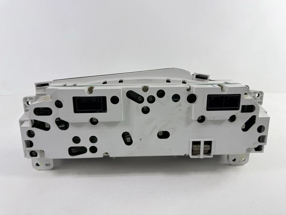 Rear view of a 2002–2004 Ford Super Duty instrument cluster showing white plastic housing and electrical connectors.