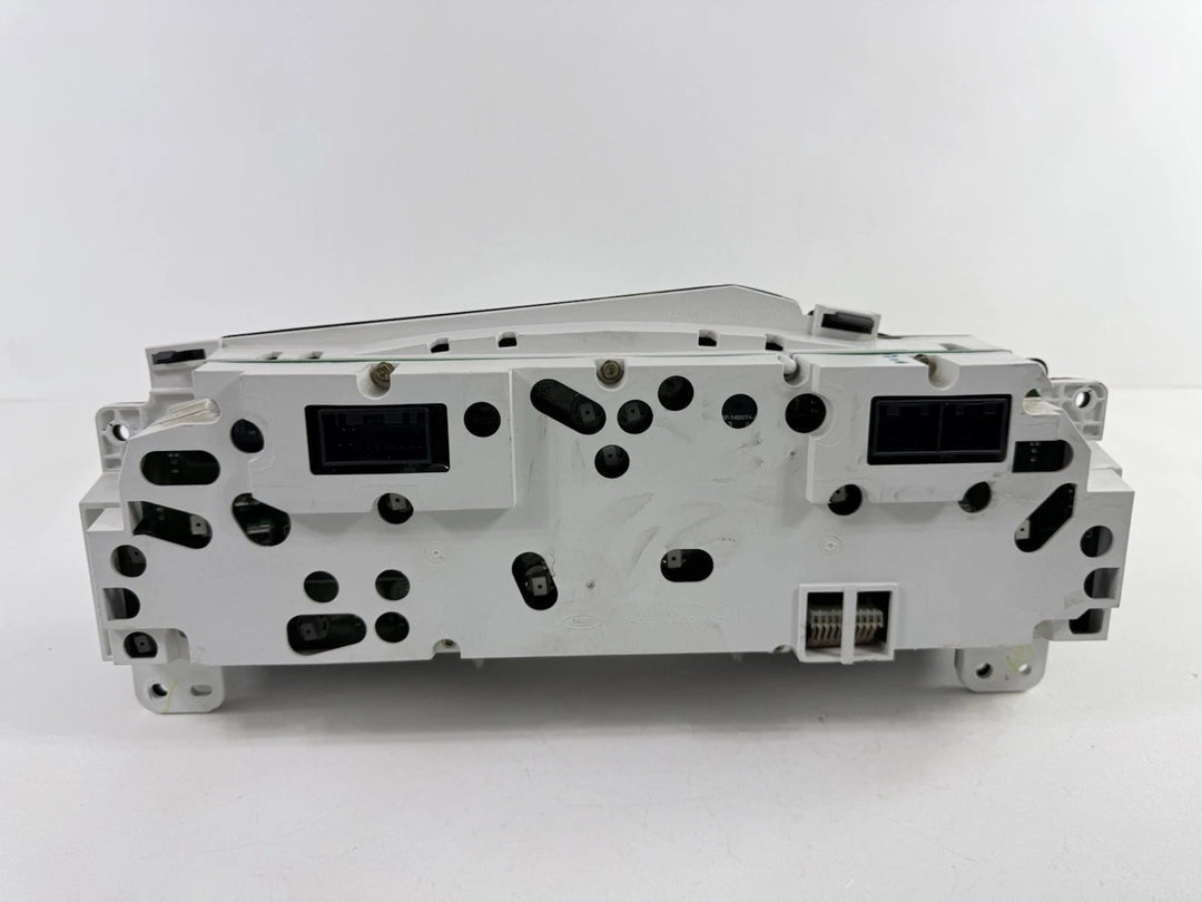 Rear view of a 2002–2004 Ford Super Duty instrument cluster showing white plastic housing and electrical connectors.