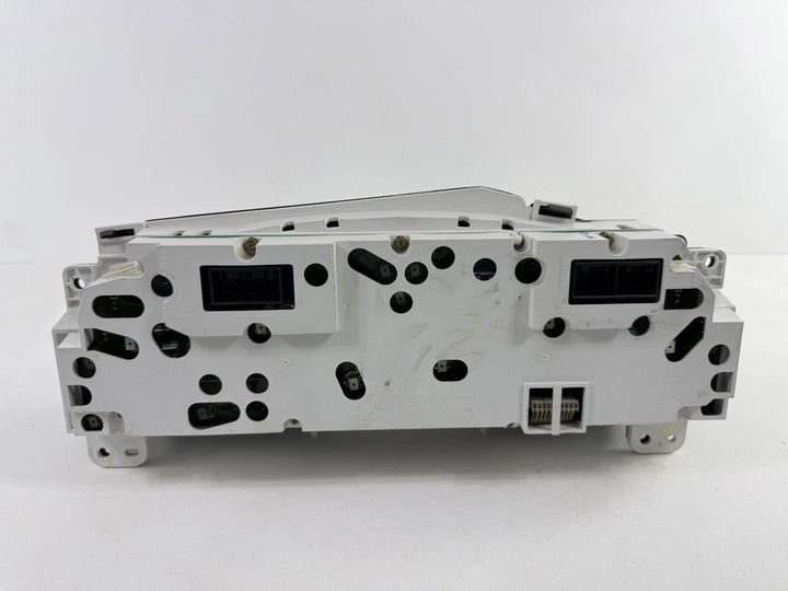 Rear view of a 2002–2004 Ford Super Duty instrument cluster showing white plastic housing and electrical connectors.