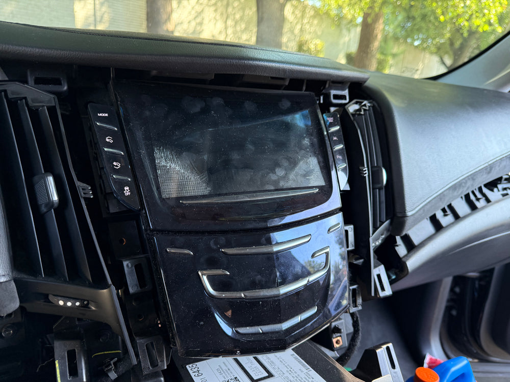 Before repair — 2018 Cadillac Escalade CUE screen with visible cracks, unresponsive touch areas, and distorted display prior to professional replacement by Module Repair Lab.