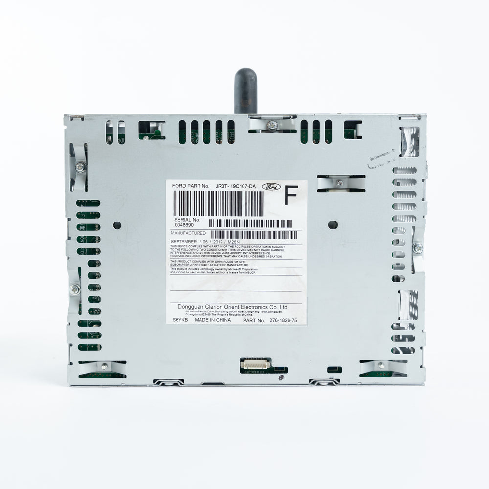 Rear view of Ford ACM Audio Control Module showing JR3T-19C107-DA label, barcode, connectors, and metal chassis for repair service at Module Repair Lab