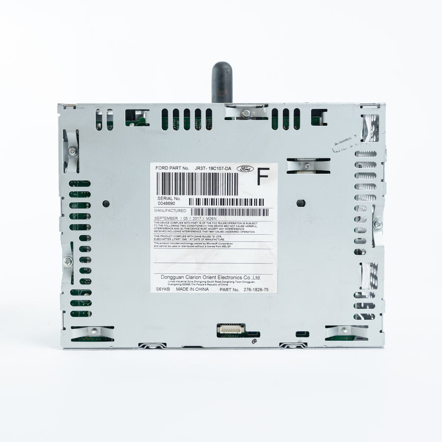 Rear view of Ford ACM Audio Control Module showing JR3T-19C107-DA label, barcode, connectors, and metal chassis for repair service at Module Repair Lab