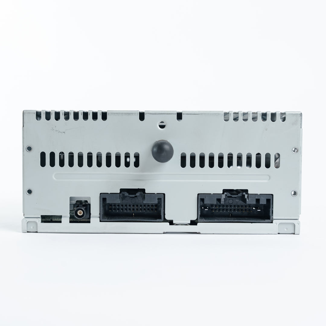 Backside of Ford ACM radio module displaying dual wiring harness connectors, ventilation slots, and antenna port used for diagnostic and repair services
