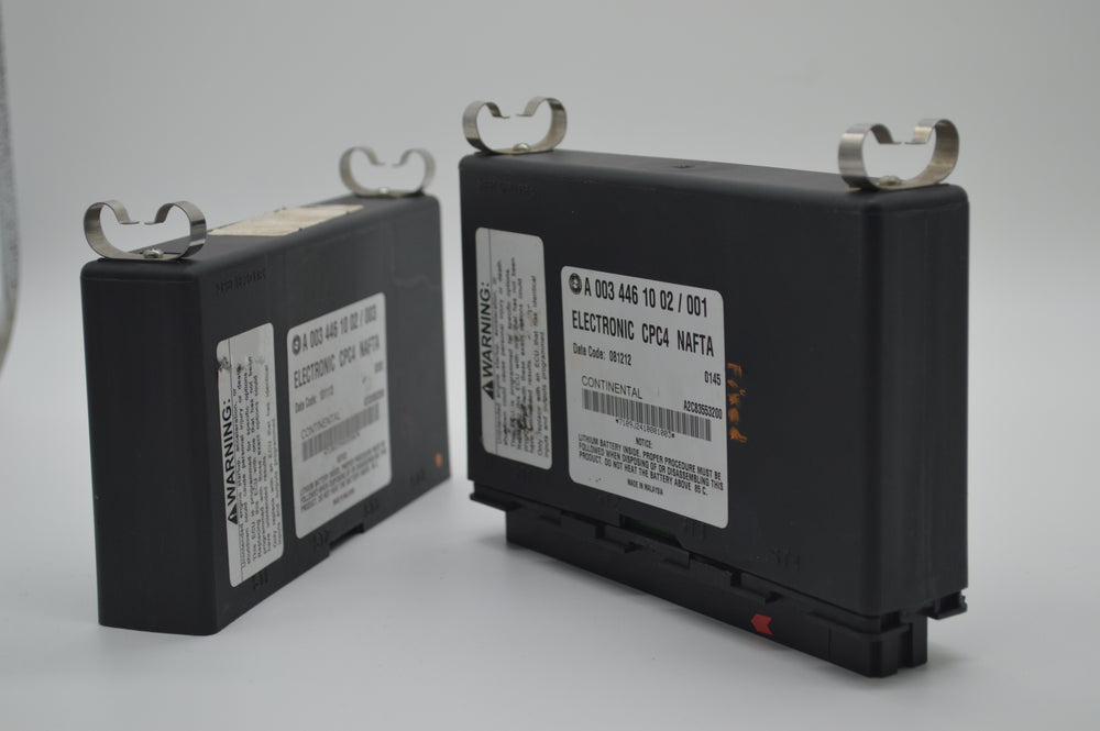 Two Freightliner CPC4 control modules labeled A0034461002/001 displayed on a white background, showing connector sides and warning labels for repair reference