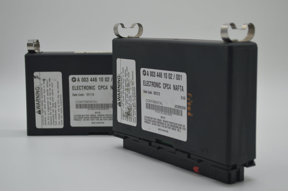 Two Freightliner CPC4 modules side-by-side, part number A0034461002 visible on both, showing electronic component detail

